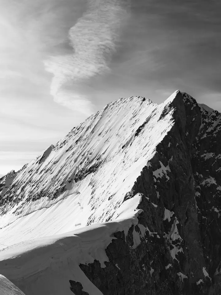 Arête enneigée de la Barre des Écrins baignée de lumière, photographie en noir et blanc — série Neige & Roche